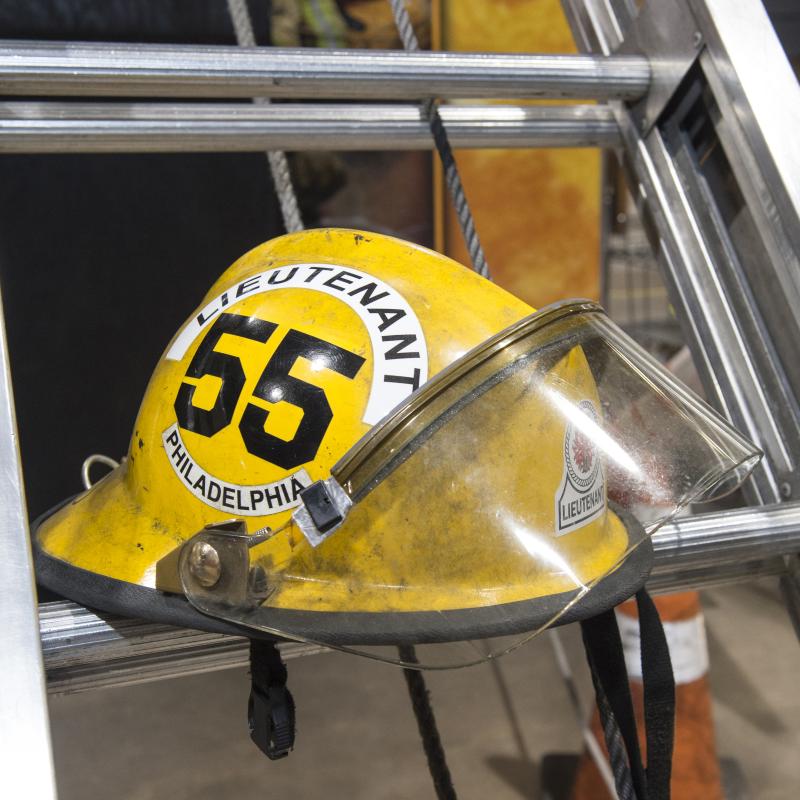 Image of firefighter helmet sitting on a ladder.