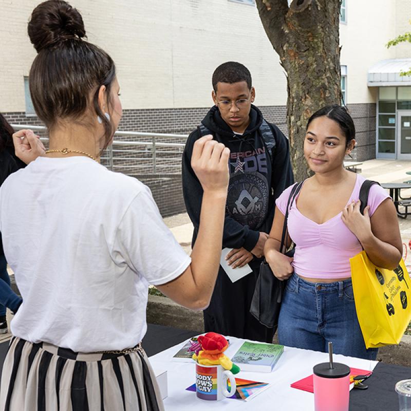 New students learn about student clubs and organizations at an outdoor tabling event on campus