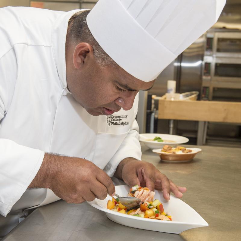 Chef arranging food onto a plate