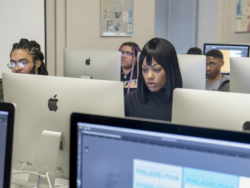 Students work at computers in computer classroom.