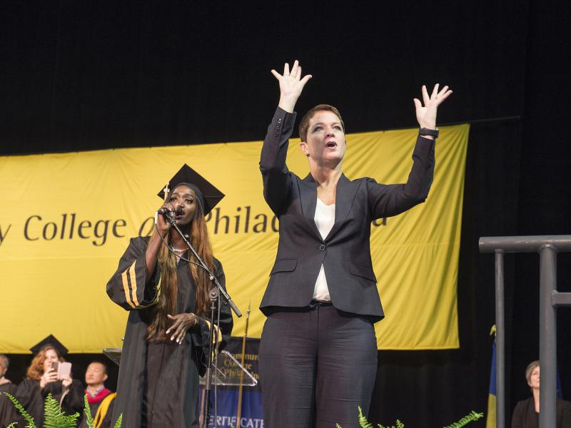 An ASL translator accompanying a student singer at the College's commencement ceremony