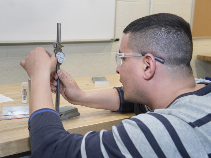 Engineering student works with a measuring tool.