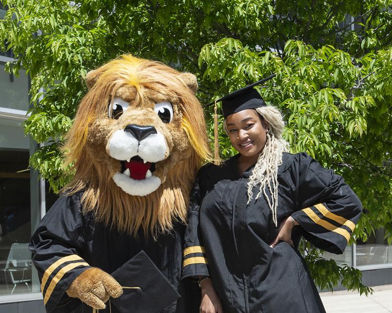 Student at Graduation standing with Roary 