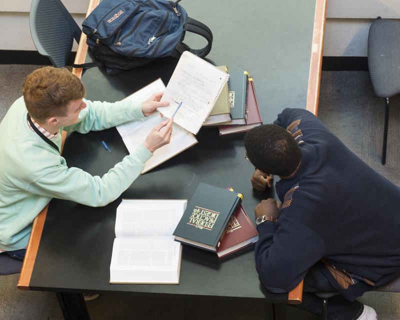 Two students sharing notes at the library.
