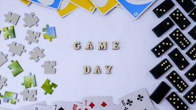 The word &quot;game day&quot; in block letters surrounded by dominos, playing cards, puzzle pieces and UNO cards