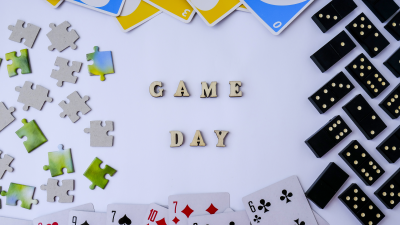 The word &quot;game day&quot; in block letters surrounded by dominos, playing cards, puzzle pieces and UNO cards