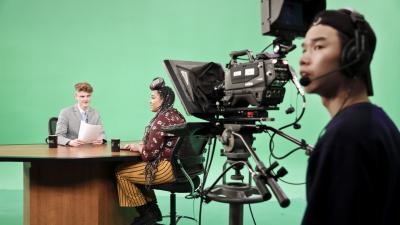 Students behind the scene on a green screen set 