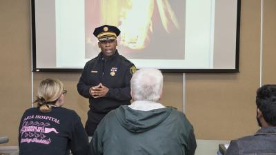 Instructor in firefighter uniform speaks to class.