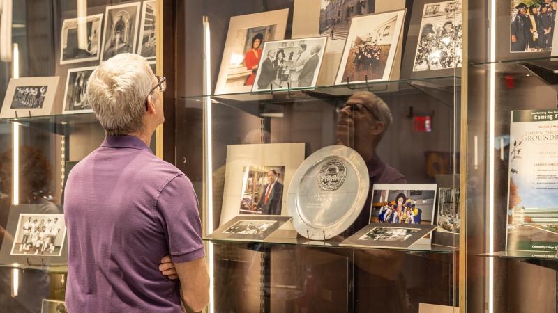 Faculty member looking at the 60th display
