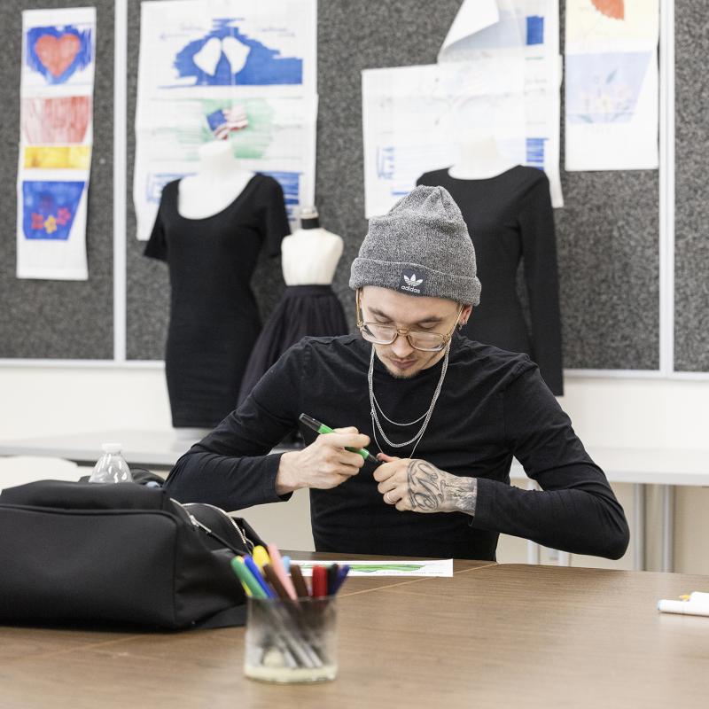 A student works on a design in the classroom.