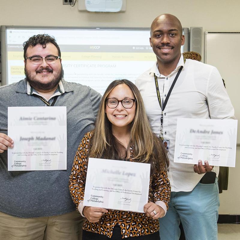 Three College staff members of different racial backgrounds pose with their Diversity Certificates after completing the College's Professional Development offering