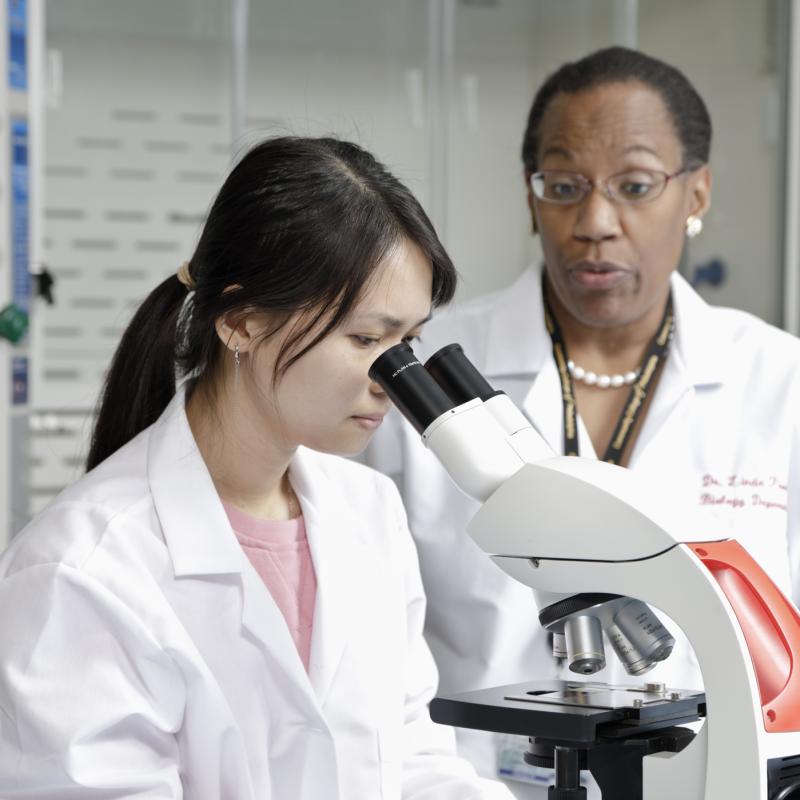 student looking into a microscope