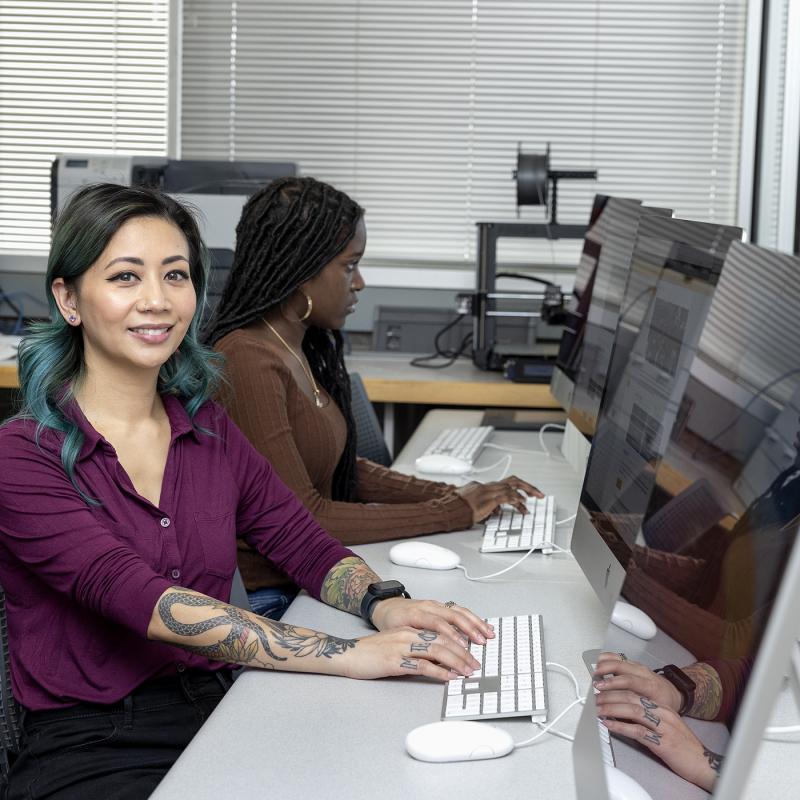 woman in a purple shirt on a computer presumably to file taxes