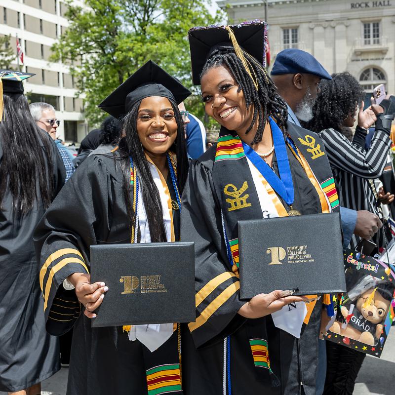 Students in graduation caps holding their diplomas