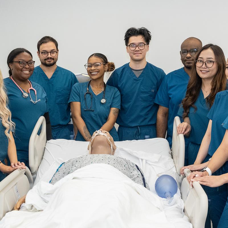 Respiratory Care Technology students posing around a lab simulation dummy