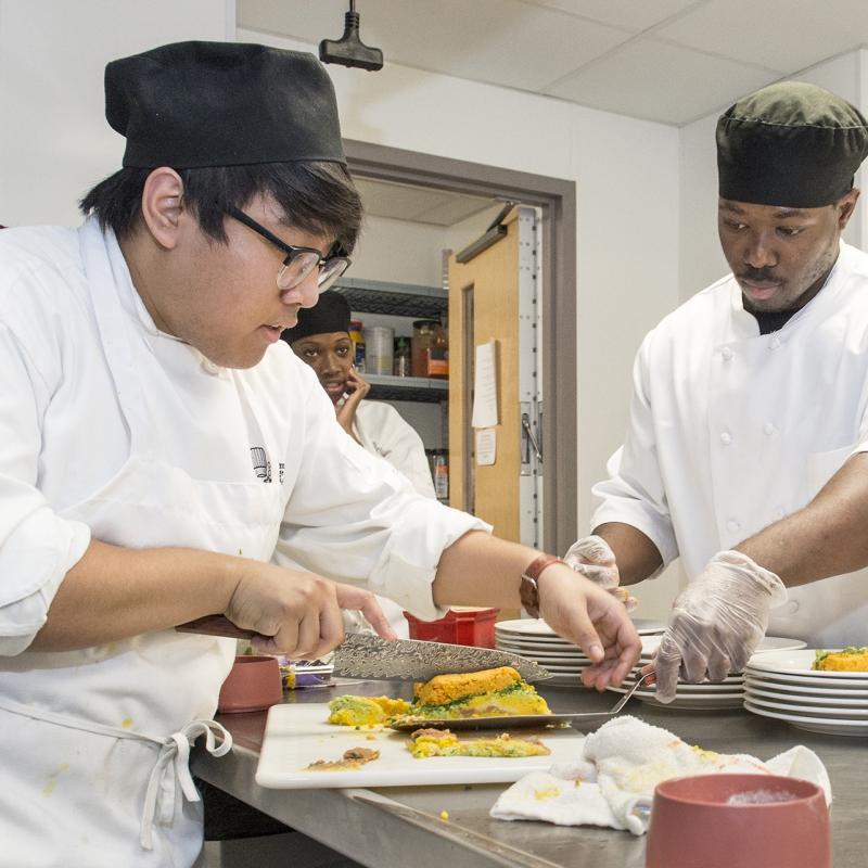Student slicing food for prep