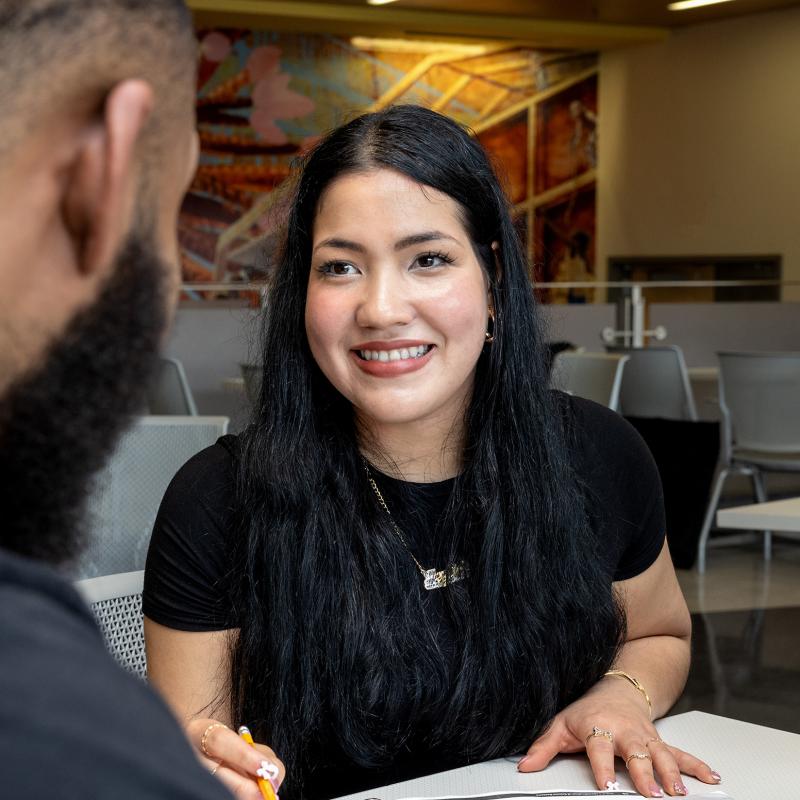 Woman in a conversation smiling.