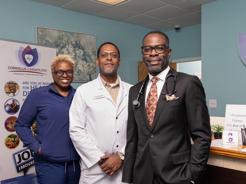 Three medical professionals posed in a doctor's office.