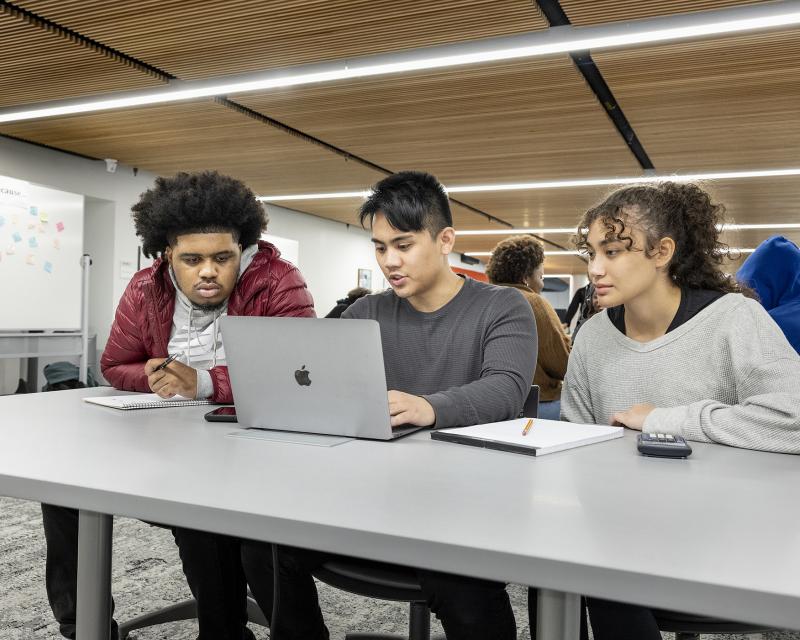 3 Students looking at laptops