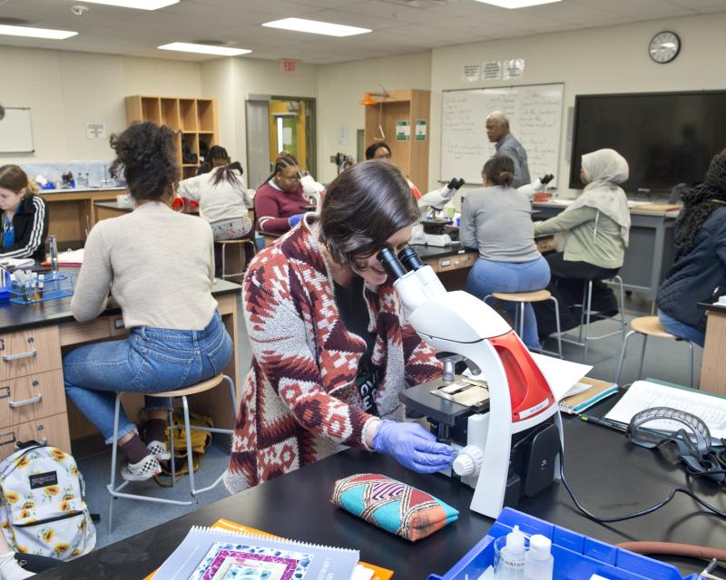student looking in a microscope