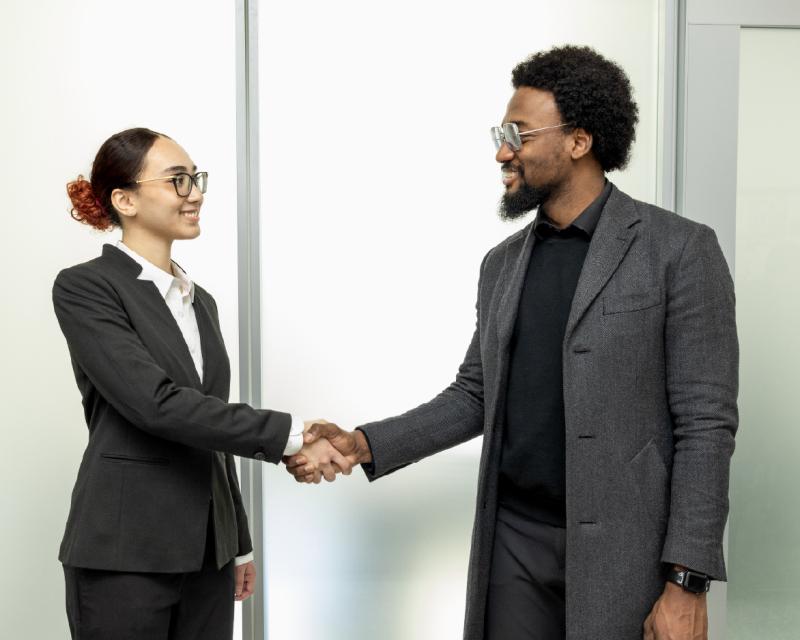 Students in business attire shaking hands