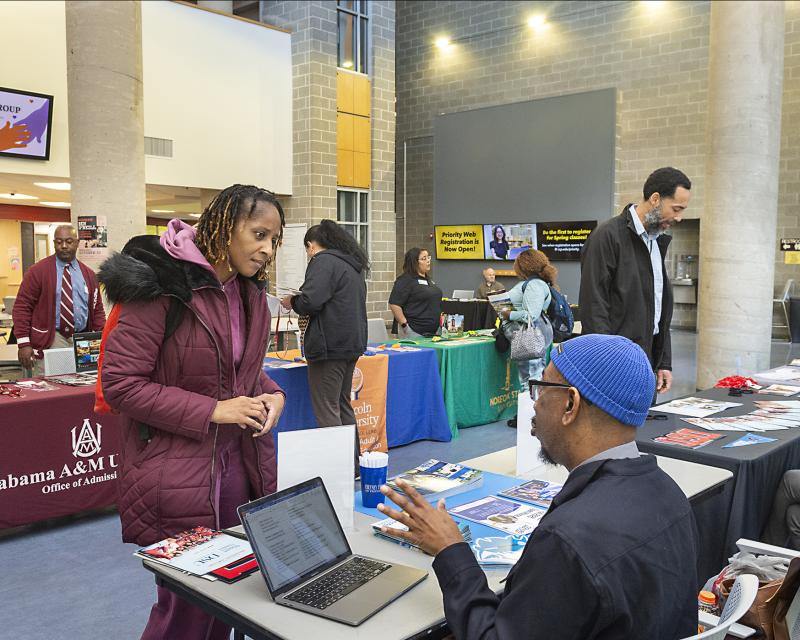 students talking to tablers at pathways fair