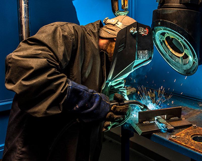 Student welding with a mask on 