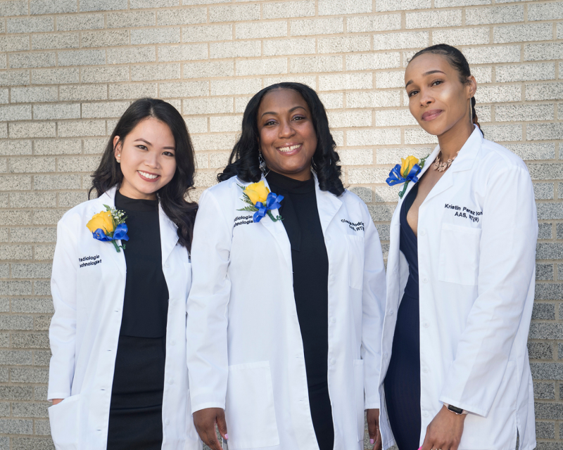 Public health students with lab coats smiling at the camers
