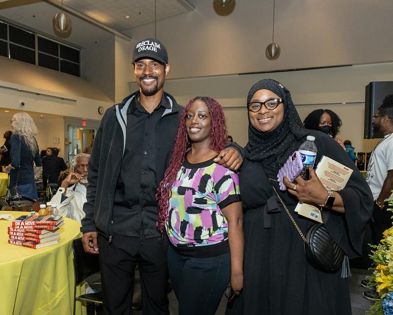 Mike Africa Jr. posing with event attendees after signing their books