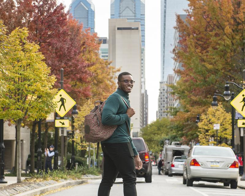 Student on 17th street, main campus, in the fall. 