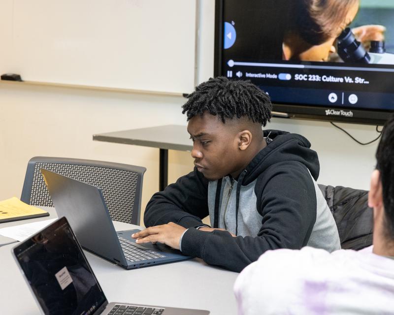 Student doing work on a laptop in class