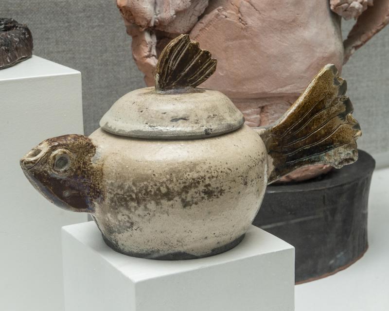 A whimsical glazed ceramic pot is on display.